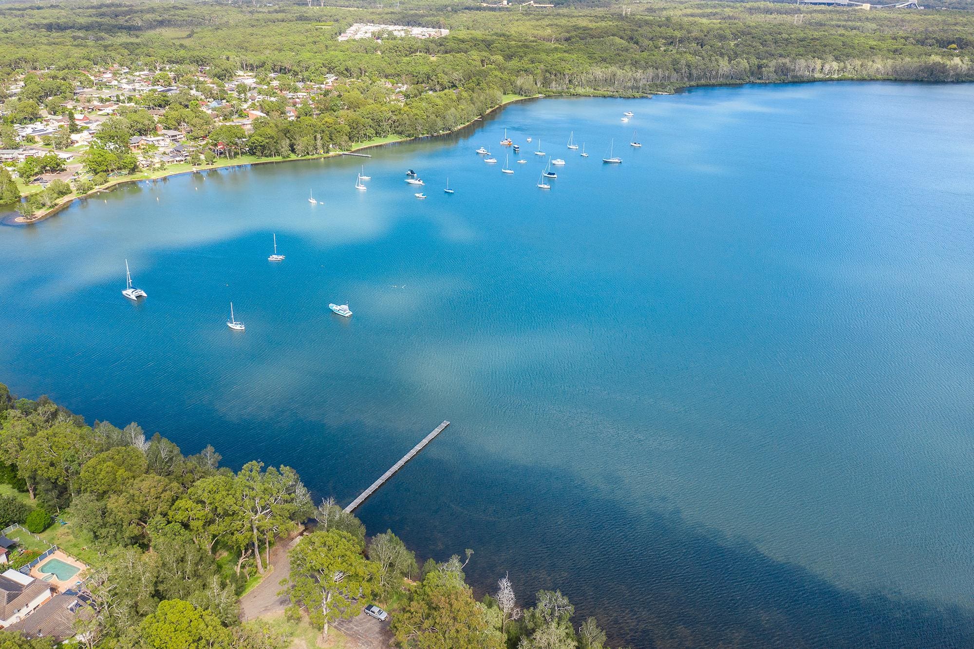 body of water with boats on and greenery all around