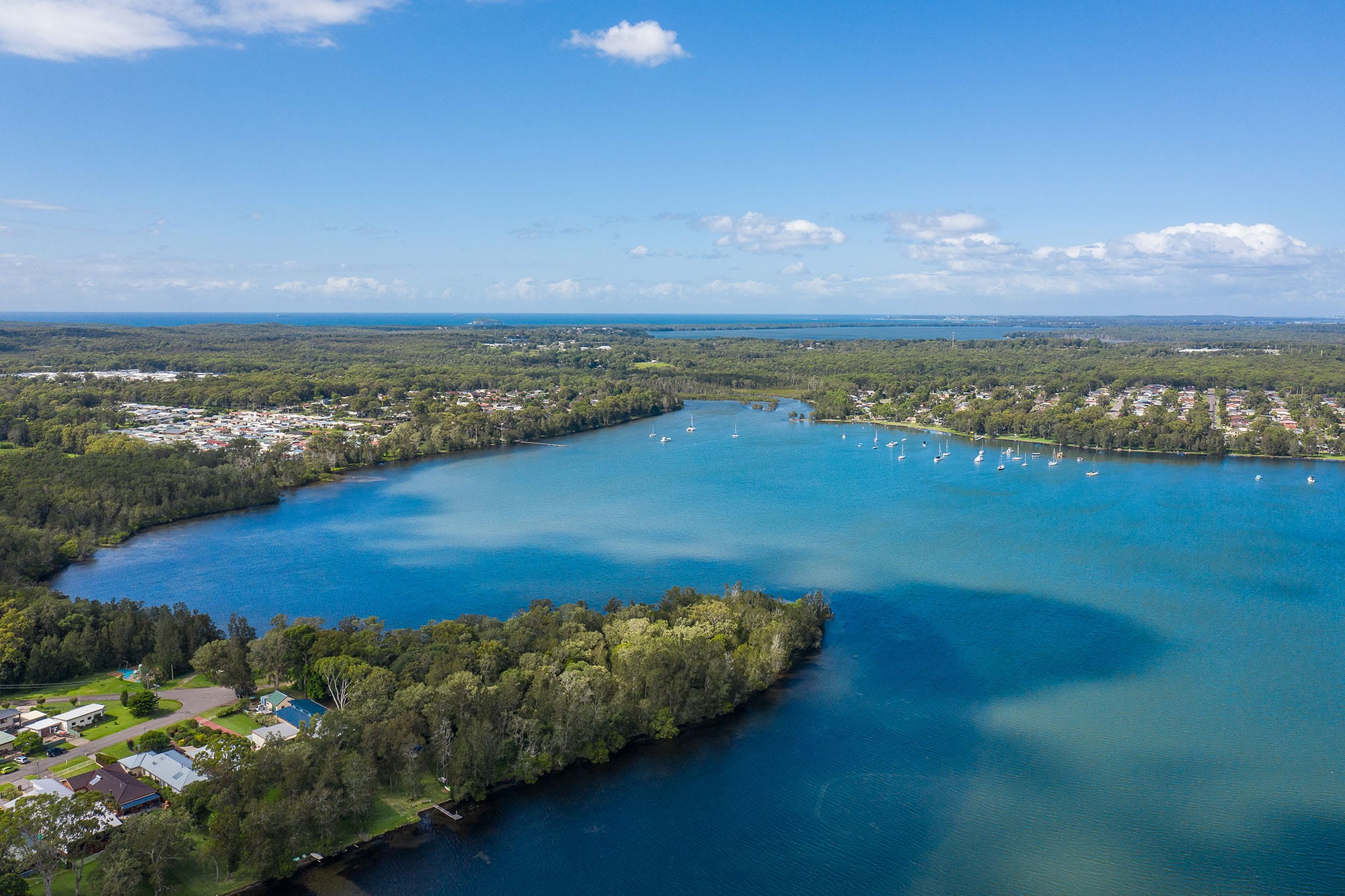 body of water with boats on and greenery all around