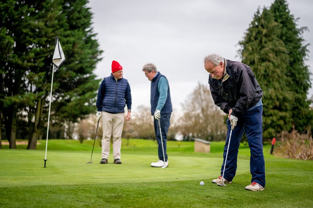 Senior men playing a round of golf and enjoying their retirement